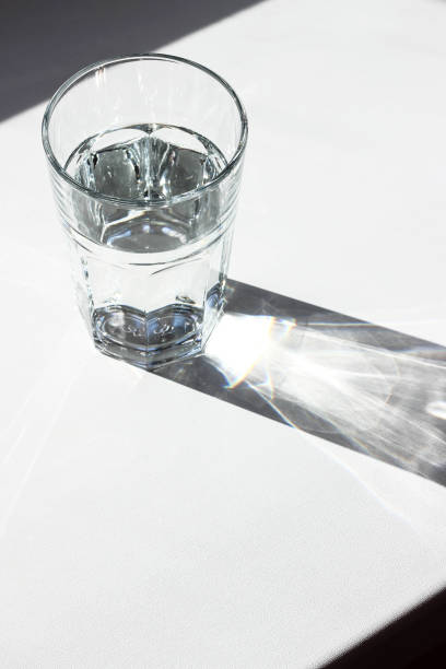 istock Water glass. Glass with strong shadows on white background 1088747784