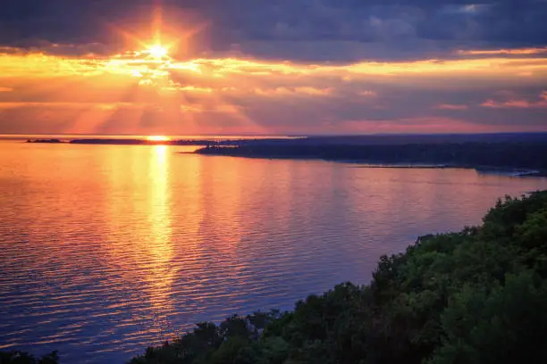 An inspiring view from the Cut River Bridge roadside park along the Lake Michigan Scenic Highway, overlooking Epoufette Bay in Michigan's Upper Peninsula. A tranquil lakeshore sunset background with copy space.