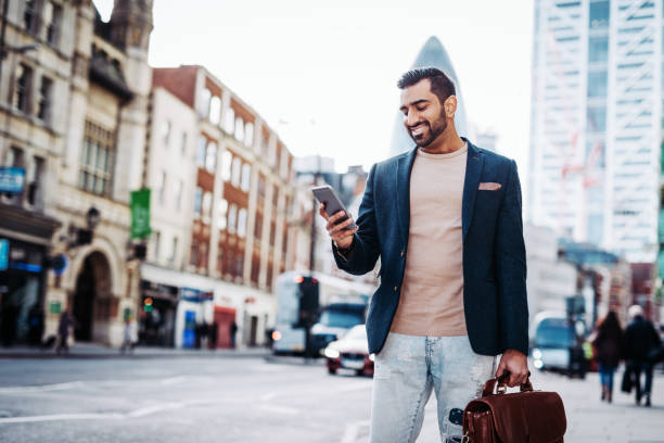 istock Millennial Indian businessman using phone while doing business in UK after Brexit 1088751432