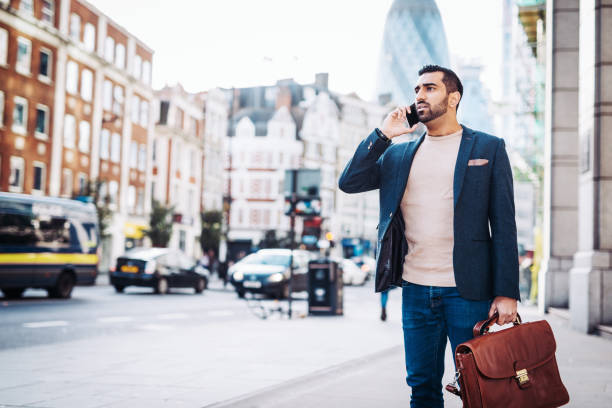 istock Millennial Indian businessman using phone while doing business in UK after Brexit 1088751498