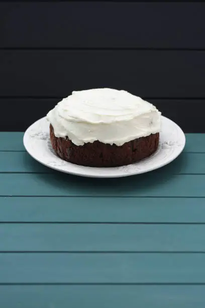 Minimalist style dessert. Chocolate cake with cream cheese on dark blue background copyspace