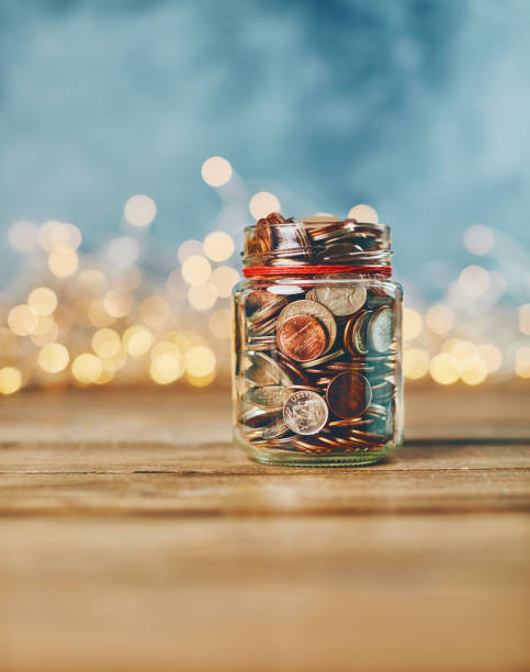 istock Brightly lit donation money jar filled with coins 1088759208