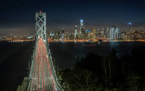 a view of the San Francisco cityscape from above the San Francisco-Oakland Bay Bridge at dusk
