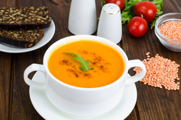 istock Red lentil soup in plate on wooden background 1088770160
