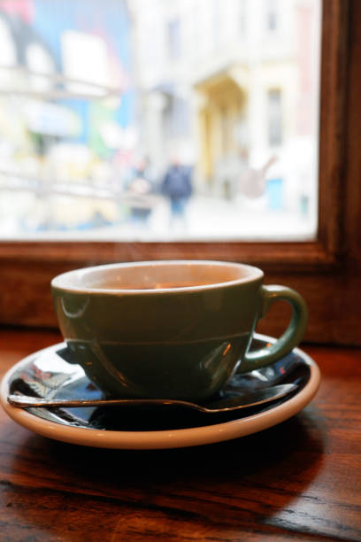istock Coffee cup on wooden table over defocused street view from cafe. 1088771566