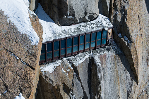 The panorama corridor partially covered by snow inset into rock face and connecting tunnels in the Aiguille du Midi lift and exhibition complex