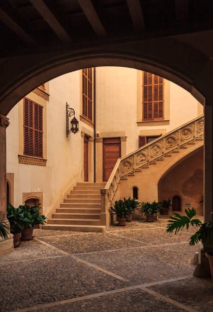 istock Old terracotta colored inner courtyard with a large staircase seen through a dark archway in a residential neighborhood in Palma de Mallorca in Mallorca on Balearic islands in Spain 1088802752