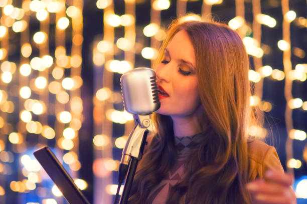 istock Female singer singing during night concert 1088816120