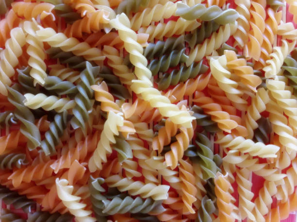 uncooked dry multicolor italian fusilli pasta. - dry pasta fusilli comfort food imagens e fotografias de stock