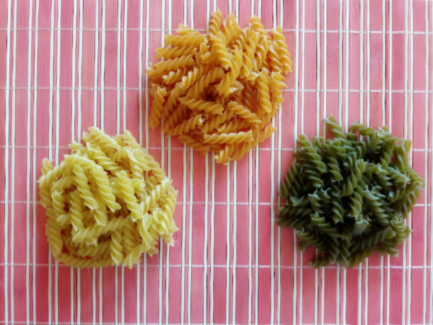 uncooked dry multicolor italian fusilli pasta. - dry pasta fusilli comfort food imagens e fotografias de stock