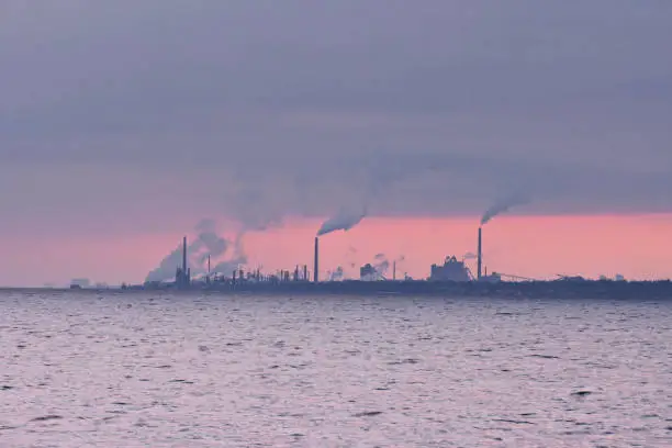 Industrial landscape of steel mills with emission of smoke in horizon over water of Lake Ontario, Canada