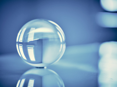 A blue color toned clear glass sphere in a home interior.
