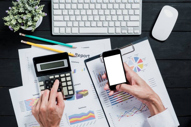 Business hand working with calculator,laptop,financial data and smart phone on desk table in office.Top view,Flat lay. Business hand working with calculator,laptop,financial data and smart phone on desk table in office.Top view,Flat lay. smart phone telephone research tax stock pictures, royalty-free photos & images