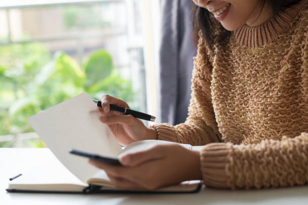 istock Close-up of smiling lady reading her notes in diary 1088834920