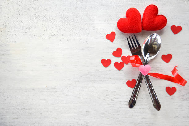 istock Valentines dinner romantic love concept Romantic table setting decorated with fork spoon and red heart on white wooden 1088835620