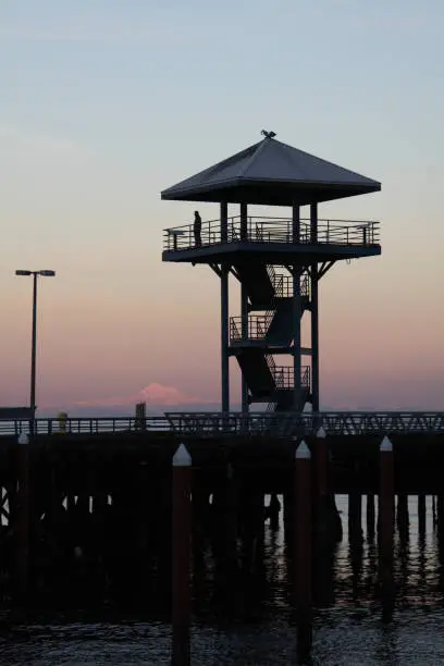 The tower on the City Pier in Port Angeles WA with Mt. Baker in the background shot at dusk in the wintertime.