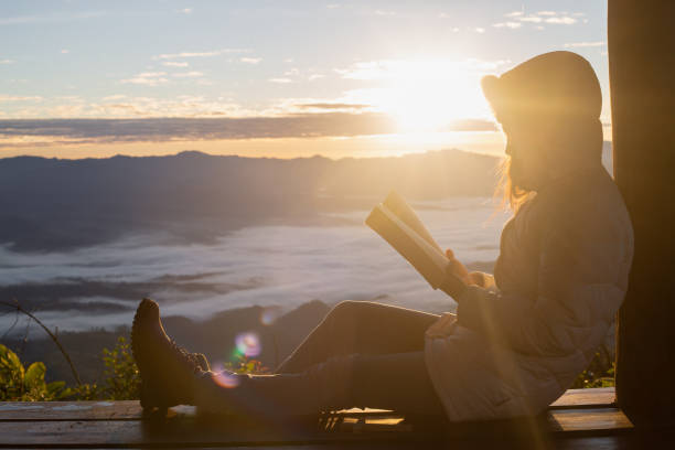 Woman holding reading Bible on Mountain in the Morning- Image Woman holding reading Bible on Mountain in the Morning- Image religious text stock pictures, royalty-free photos & images