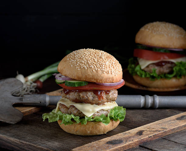 istock burger with two fried cutlets, cheese and vegetables 1088853596