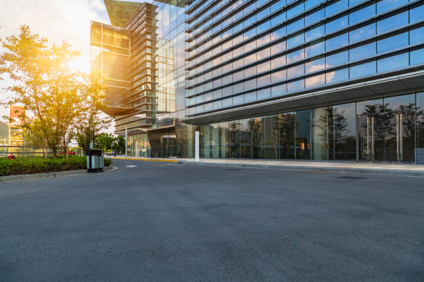Modern glass building with empty asphalt road