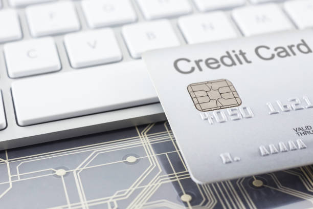 istock Silver credit card with digital circuits and keyboard. 1088860558