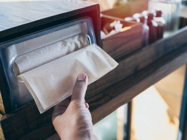 Hand picking brown napkin from the box