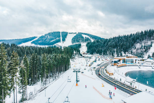 BUKOVEL, UKRAINE - December 9, 2018 - people skiing and snowboarding down by hill. winter activity