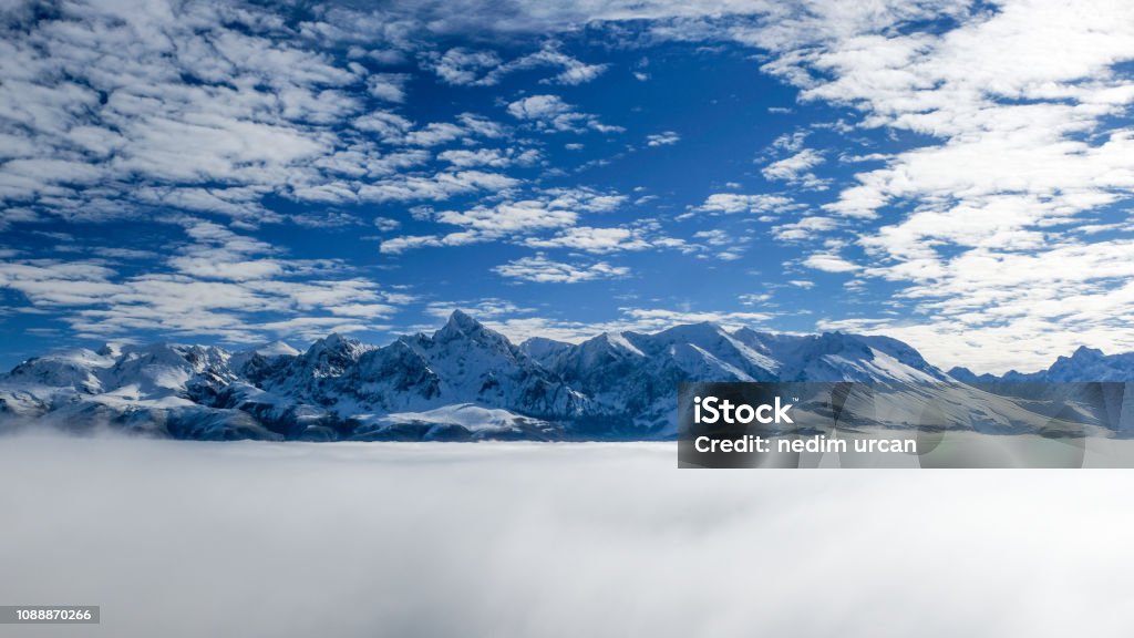 mountains and fog peaks rising above clouds Beauty In Nature Stock Photo