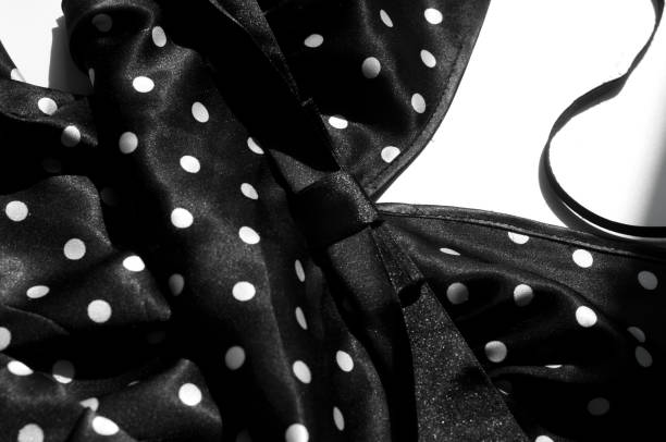istock Texture, background, pattern. Girl's skirt. Silk fabric on a black background white polka dots 1088875956