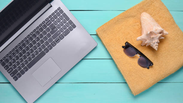 istock Online work at a beach resort. Laptop, towel, sunglasses, shell, top view, flat lay 1088876376