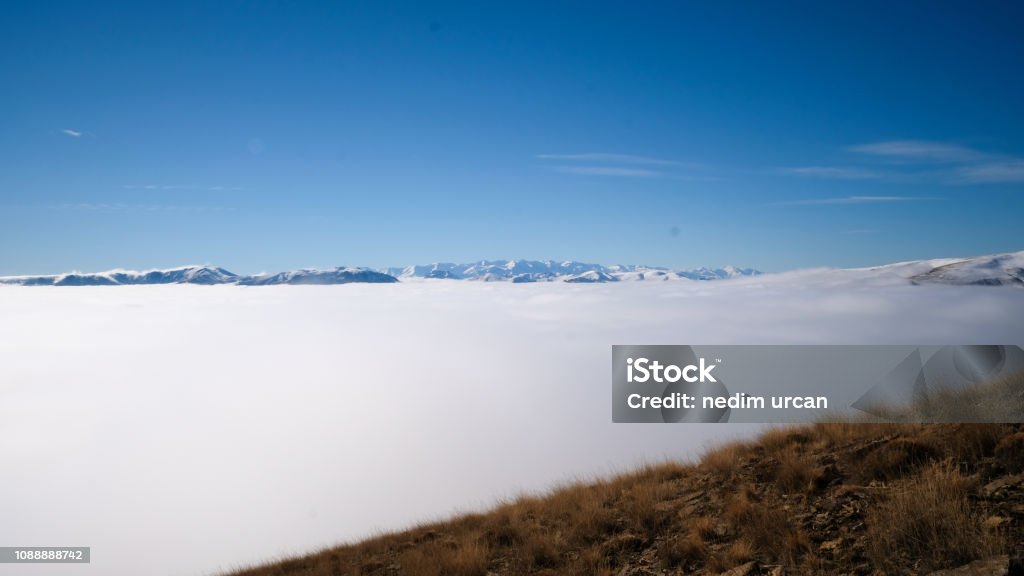 mountains and fog peaks rising above clouds Beauty In Nature Stock Photo