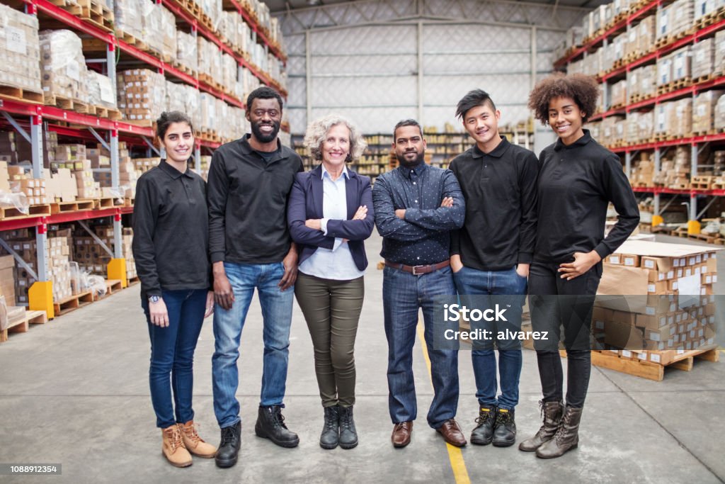 Portrait of successful logistics team Portrait of successful logistics team standing together. Senior manager with warehouse workers. Multiracial Group Stock Photo