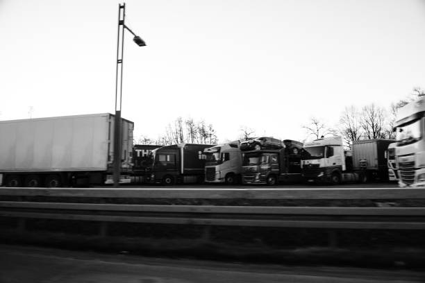 Frankfurt: Defocused view of multiple trucks parked on a parking near the autobahn on a Sunday - monochrome image