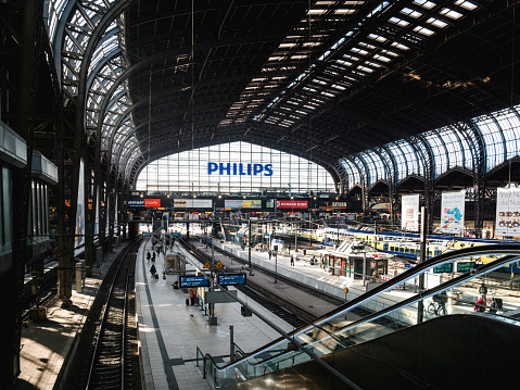 Hamburg: Hamburg Hauptbahnhof wide interior with elevated view of trains, people traveling and huge Philips advertisement