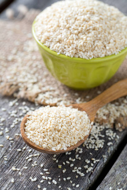 sesame seeds on wooden surface - sesame seed spoon scoop imagens e fotografias de stock