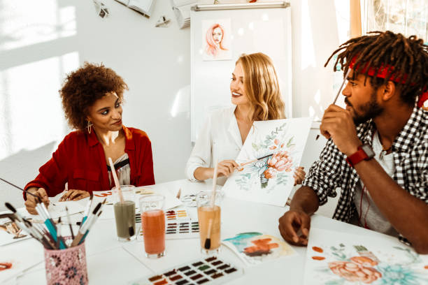 istock Talented blonde-haired art teacher sitting between her students 1088920588