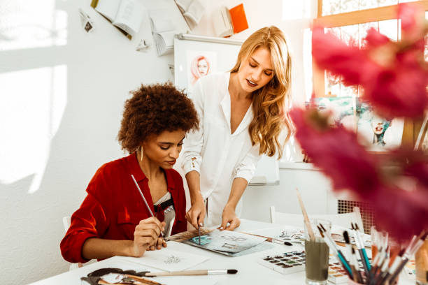 istock Beautiful stylish blonde-haired art teacher helping her student 1088920618