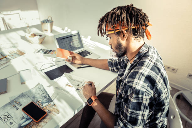 istock Interior designer with dreadlocks wearing red headband drawing sketches 1088920888