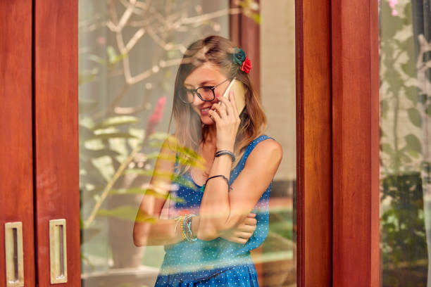 istock Young woman using smart phone indoors. Window reflection from outdoors. 1088937692