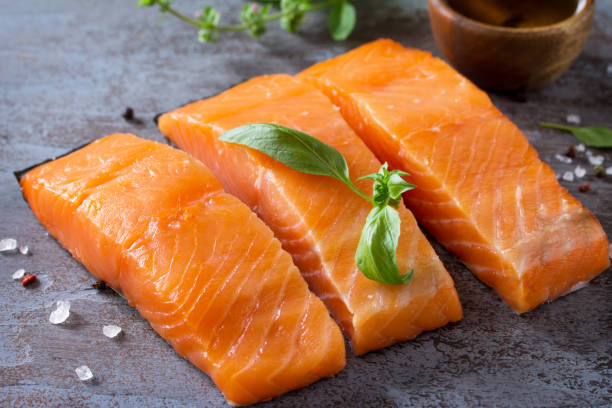 istock Fresh Fish. Raw Salmon Fillet on a dark stone table. 1088937714