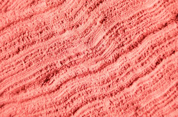 Pink cosmetic clay powder texture close up, selective focus. Abstract background with brush strokes.