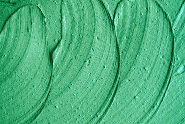 istock Green cosmetic clay (facial mask, cream, body scrub) texture close up, selective focus. Abstract background with brush strokes. 1088941864