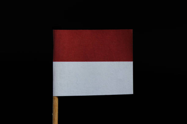 istock A unique and very simple flag of Monaco on toothpick on black background. A two equal horizontal bands, red and white 1088942068