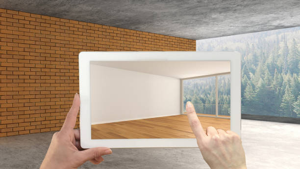istock Augmented reality concept. Hand holding tablet with AR application used to simulate furniture and design products in an interior construction site, empty interior with panoramic window 1088946838