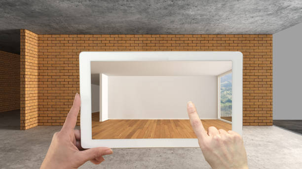 istock Augmented reality concept. Hand holding tablet with AR application used to simulate furniture and design products in an interior construction site, empty interior with panoramic window 1088952086