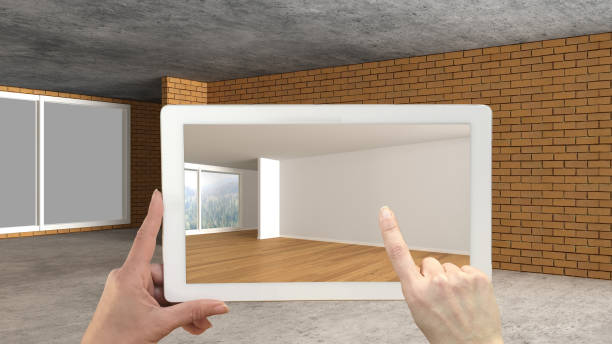 istock Augmented reality concept. Hand holding tablet with AR application used to simulate furniture and design products in an interior construction site, empty interior with panoramic window 1088952106