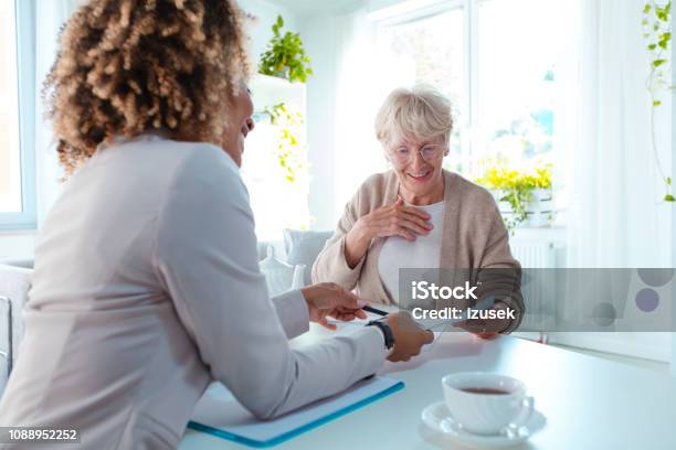 Senior Woman Talking With Financial Advisor Stock Photo - Download Image Now - Senior Adult, Financial Advisor, Advice