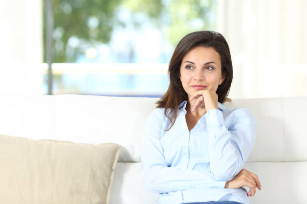 istock Pensive homeowner sitting on a couch at home 1088954930