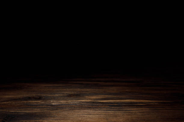 istock dark brown striped wooden tabletop on black 1088958138