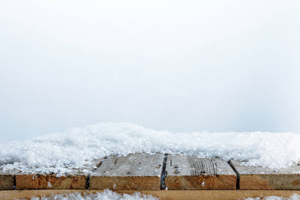 striped wooden fence covered with snow on white