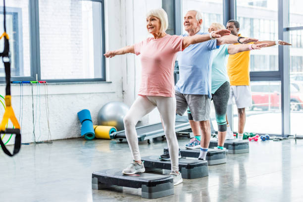 istock multicultural senior athletes synchronous exercising on step platforms at sports hall 1088958456